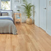 White bedroom with a palm tree and night stand beside the bed on French Oak VGW85T floors