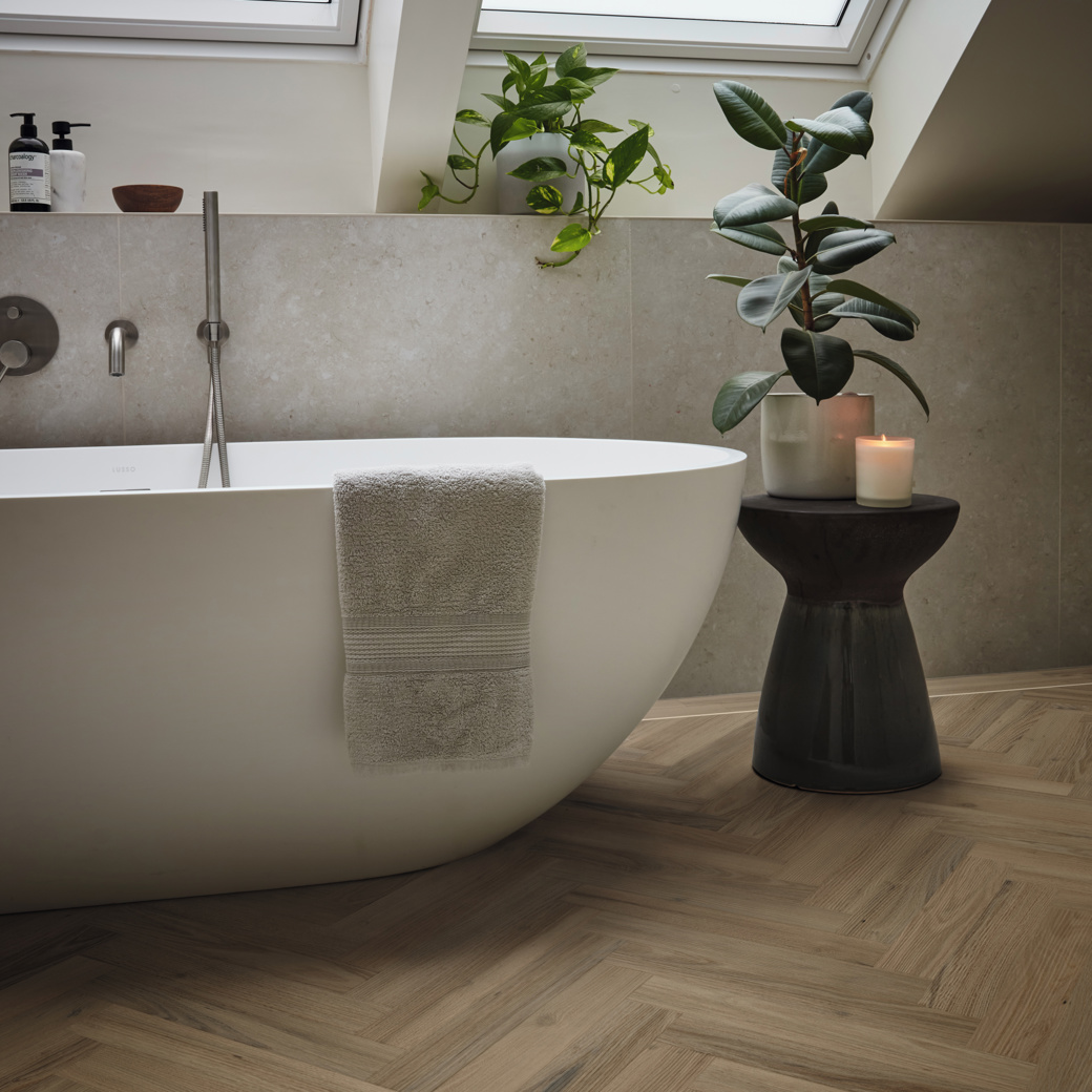 Duxbury Acacia dark brown herringbone LVT flooring laid next to a bath